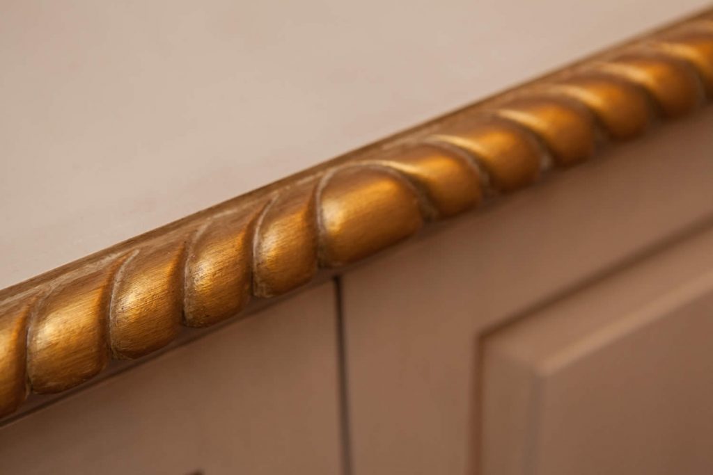 Cabinetry detail showing carved gadrooned front edge with gilt accents.<br>Private Residence. London. 2015.